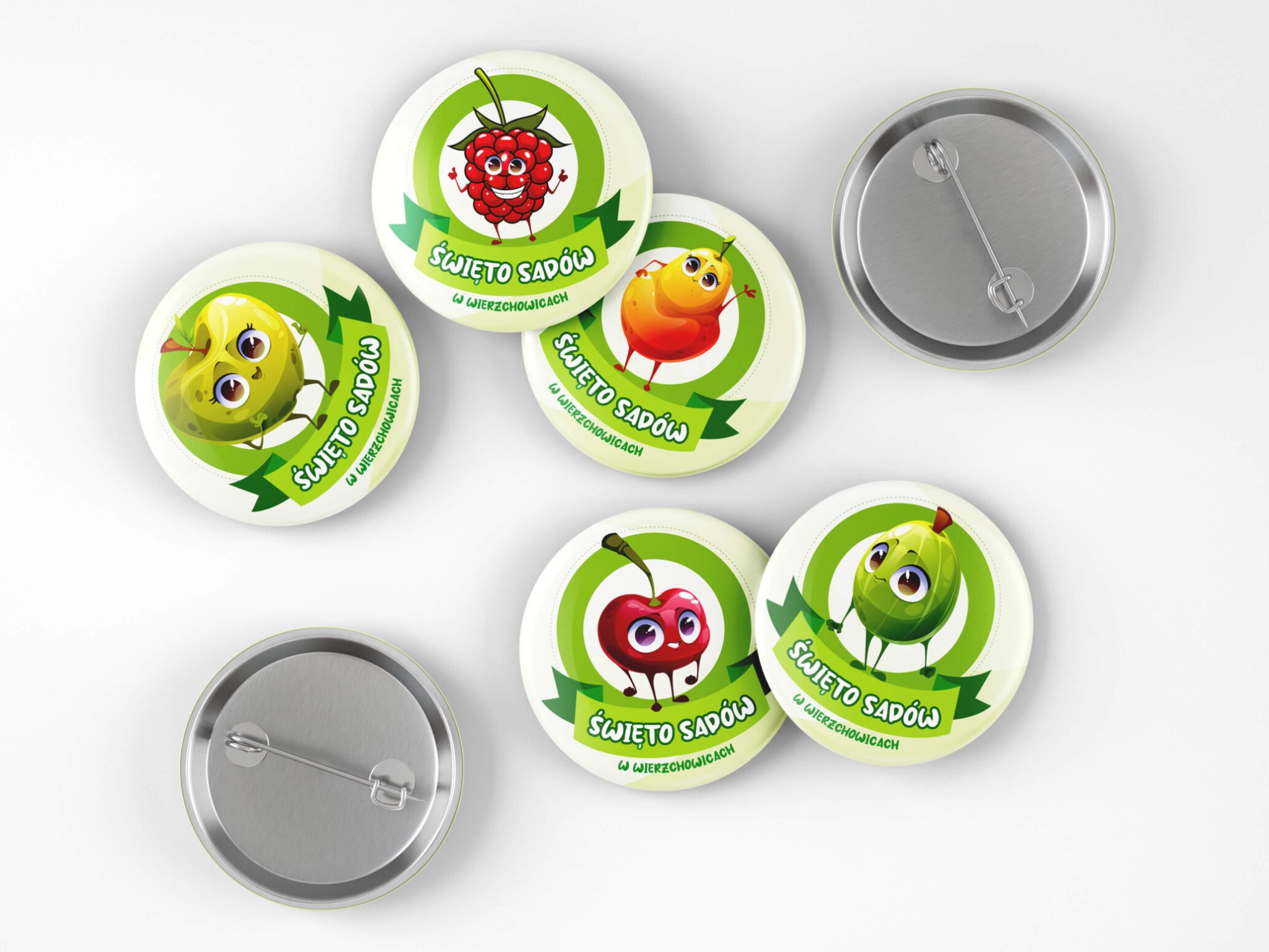 Zestaw okrągłych przypinek z grafikami owoców (malina, jabłko, gruszka, wiśnia, agrest) w stylu cartoon, z napisem 'Święto Sadów w Wierzchowicach', widoczne także metalowe elementy mocujące.