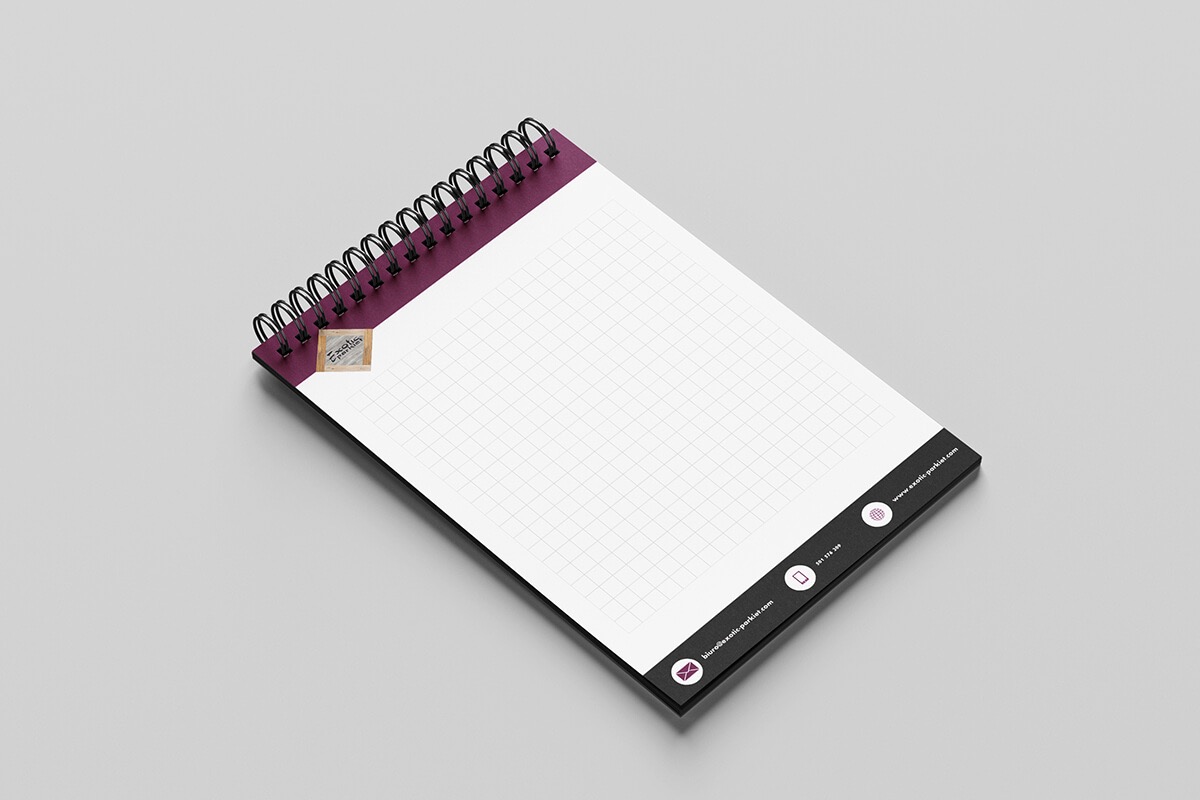 Notatnik spiralny z fioletową okładką i siatką w kratkę, z nadrukowanymi danymi kontaktowymi firmy na dolnej krawędzi.