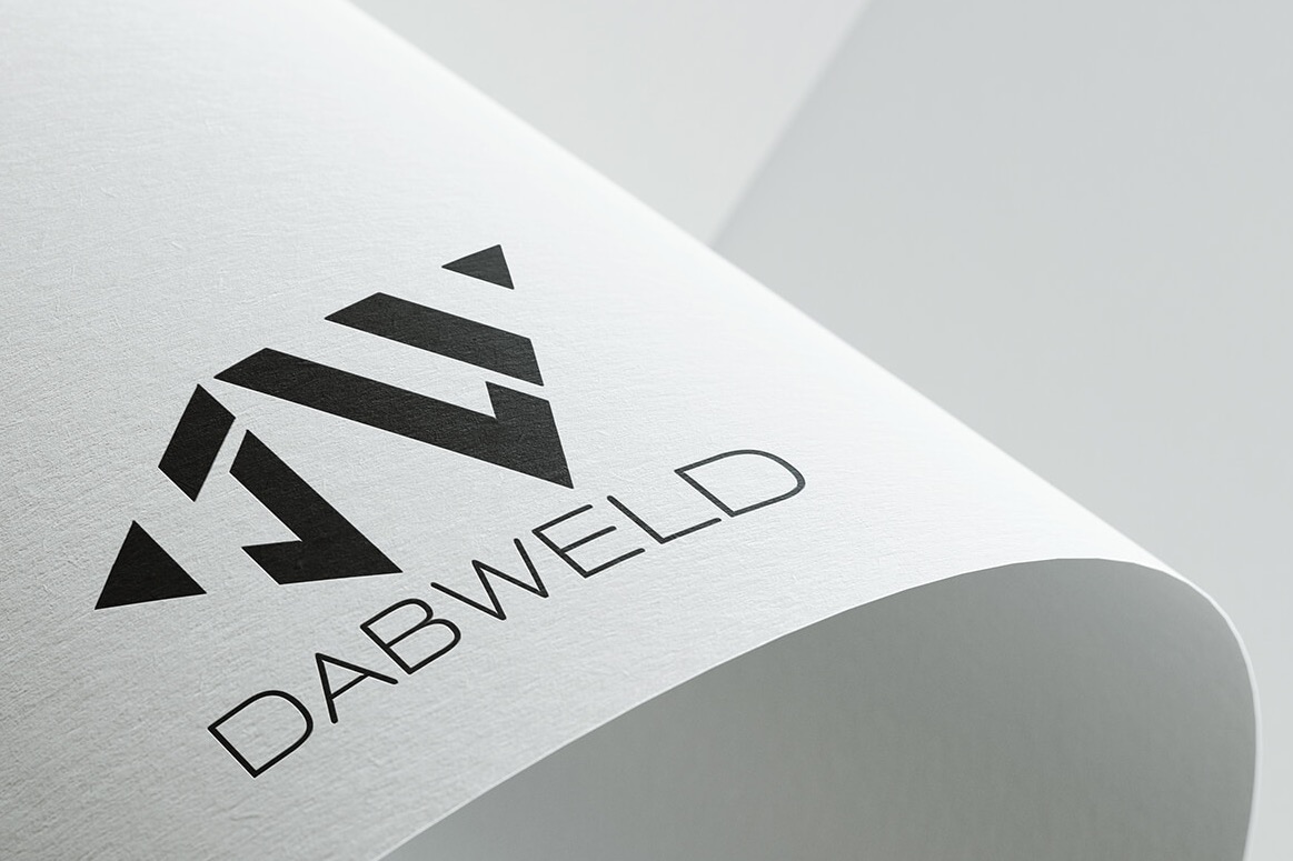 Logo 'DABWELD' w kolorze czarnym, umieszczone na białej, zakrzywionej kartce papieru o delikatnej fakturze. Logo składa się z geometrycznego symbolu i nazwy firmy napisaną prostą czcionką.