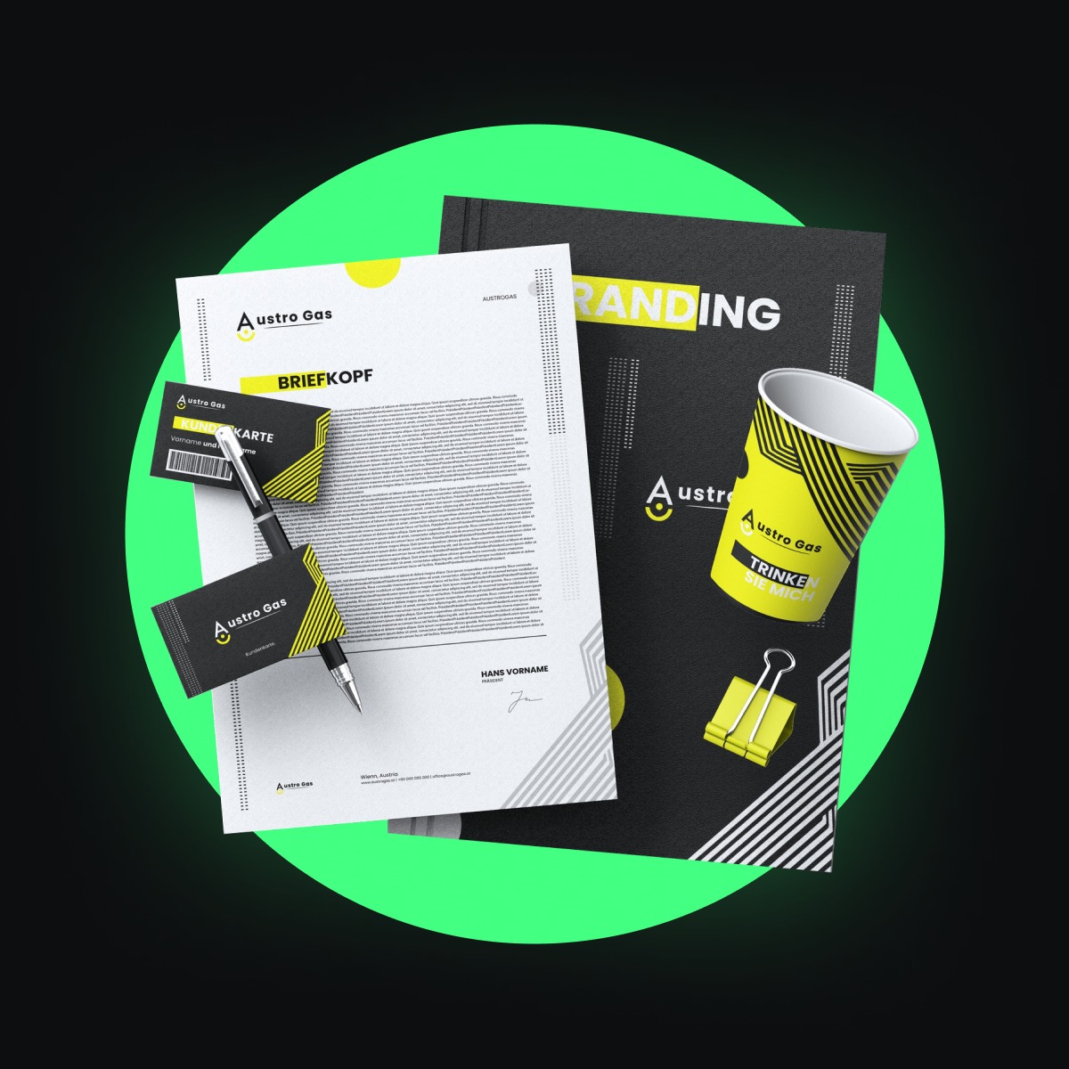 Zestaw identyfikacji wizualnej firmy Austro Gas, zawierający papier firmowy, wizytówki, kubek i folder brandingowy, wszystko w kolorach czerni, bieli i żółci, ułożone na ciemnym tle z zieloną aureolą.