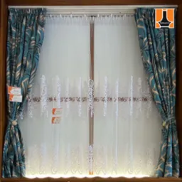 Okno z firanką z białym haftem i zasłonami w turkusowe liście, upięte sznurkiem z ozdobnym guzikiem, widoczne metki z cenami.