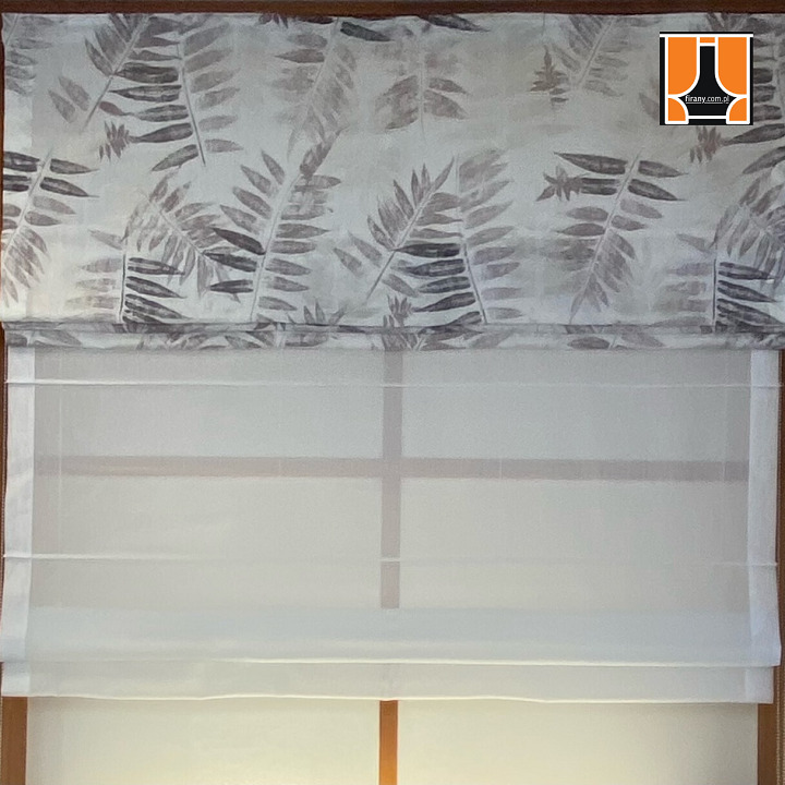 Delikatna roleta rzymska z motywem liści w Tychach, częściowo opuszczona, przepuszczająca światło dzienne.