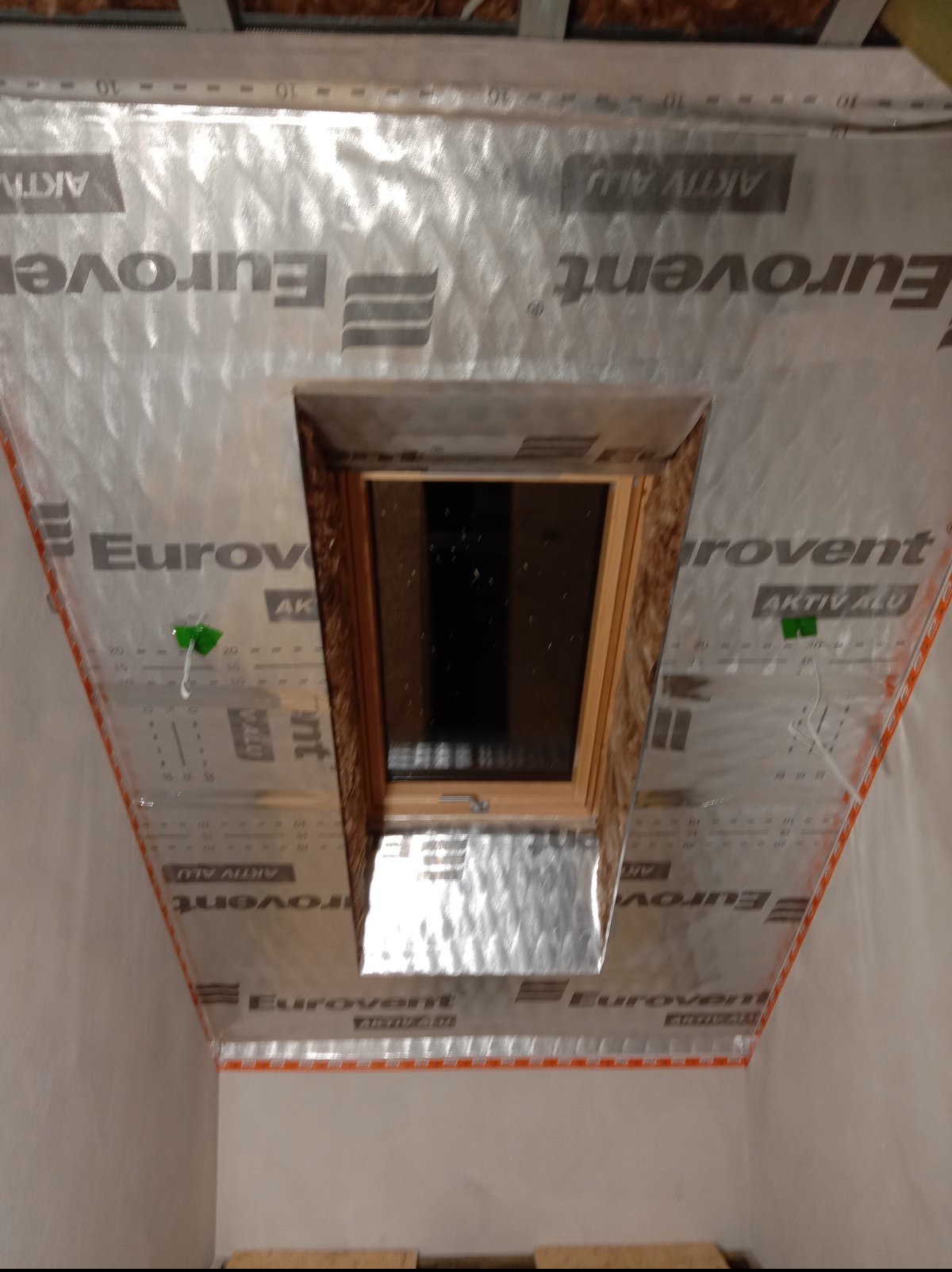 Montaż okna dachowego z folią paroizolacyjną Eurovent Aktiv Alu, widok od wewnątrz. Detal wykończenia, izolacja termiczna poddasza.