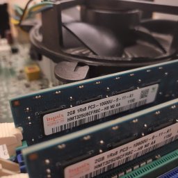 lublin.host KAROL RÓŻAŃSKI - Wnętrze komputera stacjonarnego z bliska: dwa moduły pamięci RAM Hynix 2GB PC3-10600U, widoczne gniazda i radiator procesora. Detaliczna perspektywa.