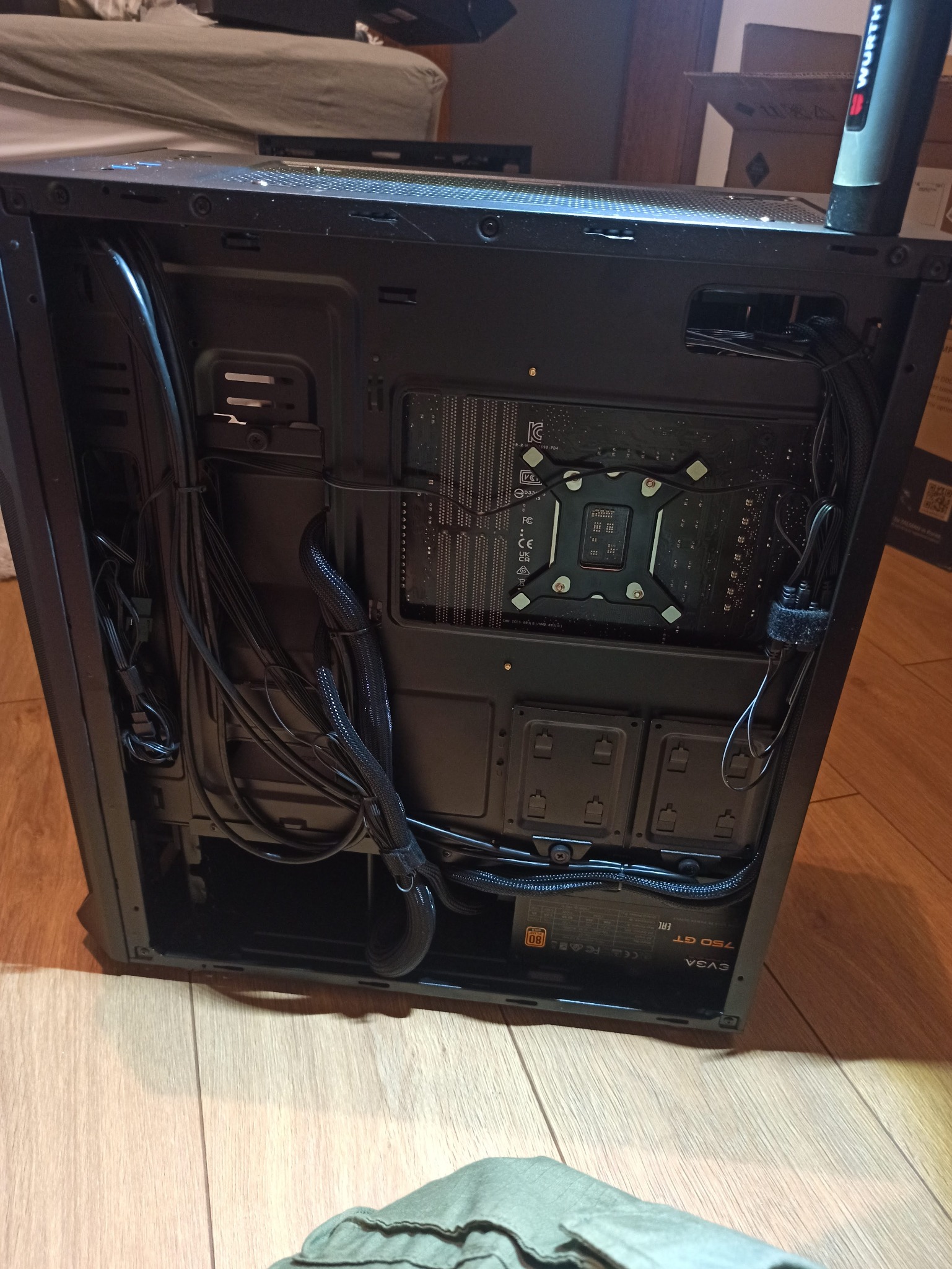 Wnętrze obudowy komputera stacjonarnego z widocznymi kablami, płytą główną i zasilaczem EVGA 750 GT. Uporządkowane przewody w czarnych oplotach.