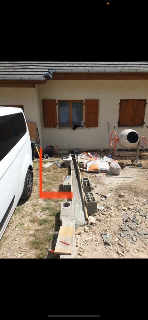 Wykonywanie fundamentów pod budynek w Rzeszowie: widoczny betonowy fundament, bloczki betonowe, betoniarka oraz samochód dostawczy firmy.