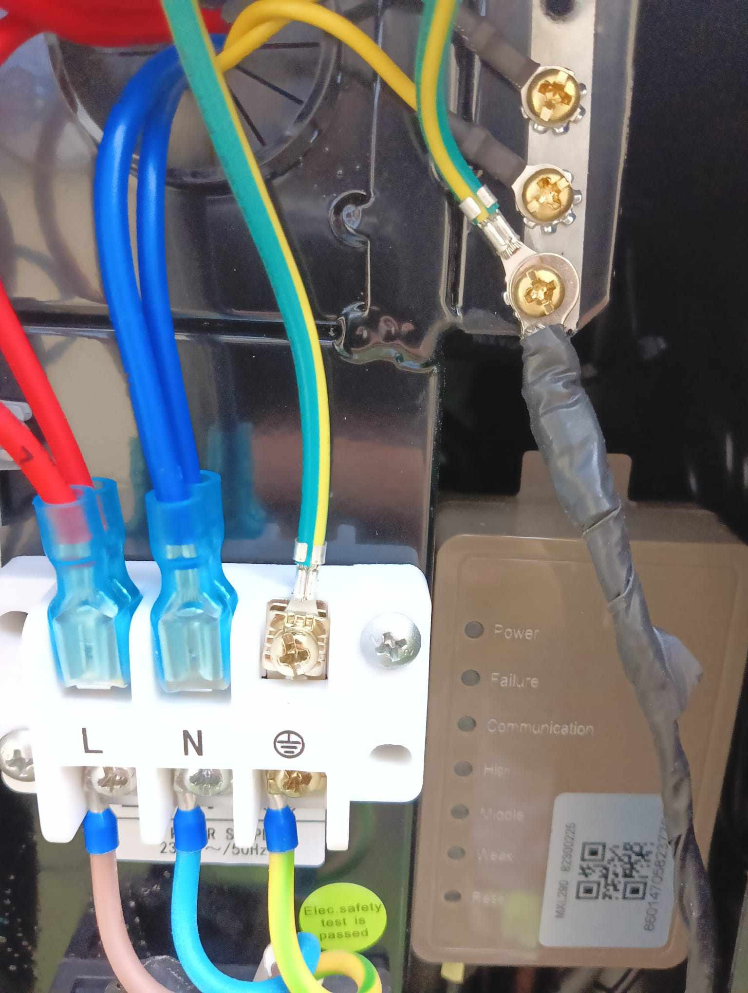 Szczegółowe ujęcie panelu elektrycznego z kolorowymi przewodami (czerwony, niebieski, żółto-zielony) podłączonymi do zacisków L, N i uziemienia, widoczne wskaźniki LED (Power, Failure...