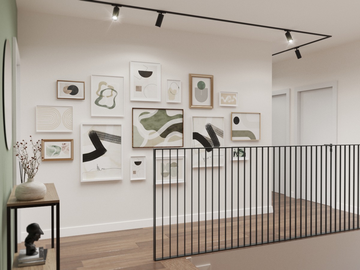 Korytarz z galerią obrazów na ścianie, oświetlony reflektorami na szynie, widoczne schody z czarną balustradą.