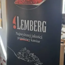 Rollup reklamowy z grafiką kawioru firmy Lemberg z adresem strony internetowej i kodem QR, wykonany w Police. Ciemne tło, srebrna podstawa.