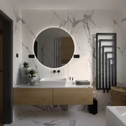 Nowoczesna łazienka z marmurowymi ścianami, okrągłym lustrem z podświetleniem LED, drewnianą szafką pod umywalką, grzejnikiem drabinkowym i roślinami w kamiennych donicach.