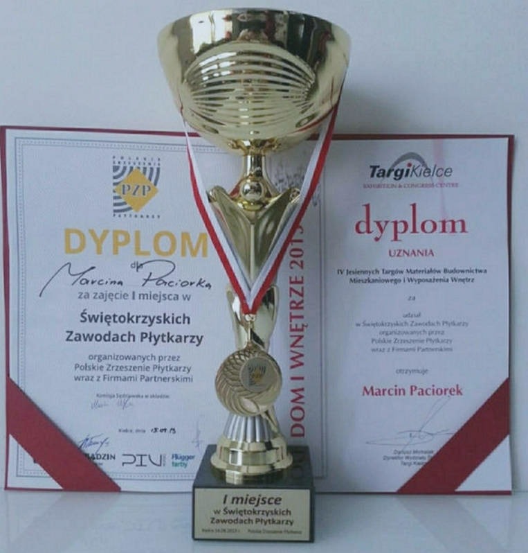 Złoty puchar i dyplomy dla Marcina Paciorka za zajęcie I miejsca w Świętokrzyskich Zawodach Płytkarzy, z logo Polskiego Zrzeszenia Płytkarzy i Targów Kielce.