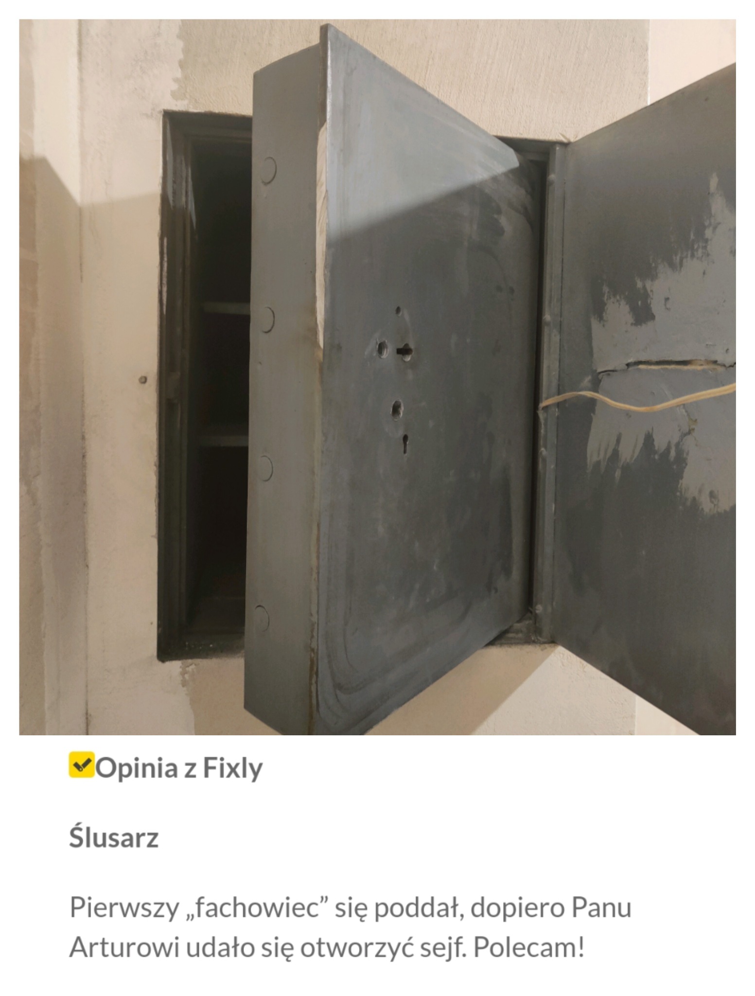 Otwarty, szary sejf wmurowany w ścianę z widocznymi półkami wewnątrz.