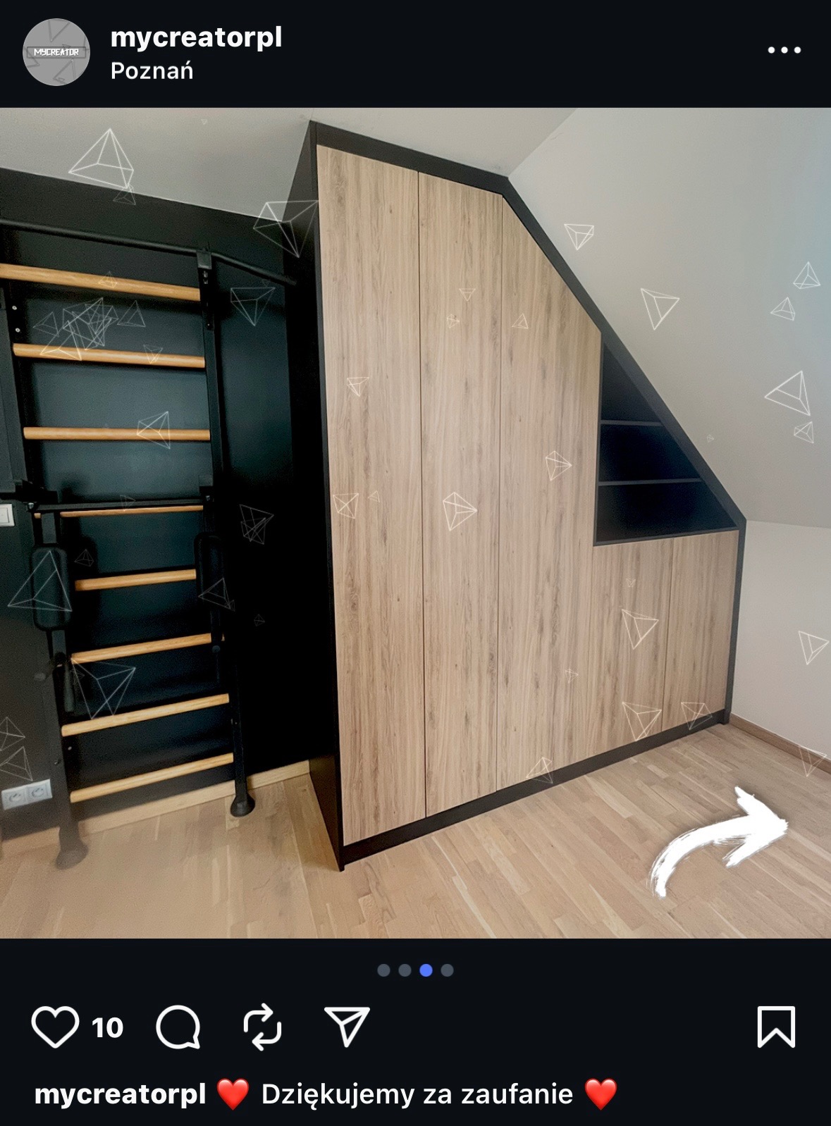 Drewniana szafa wnękowa na poddaszu, z czarnymi detalami i drabinką gimnastyczną obok. Ukośny sufit, jasna podłoga. Minimalistyczny design.