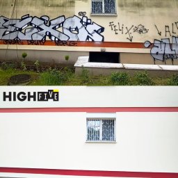 High five usługi alpinistyczne - Zdjęcie elewacji budynku przed i po usunięciu graffiti. Górna część z graffiti, dolna po czyszczeniu, z logo firmy na środku. Widoczne okna z kratami i roślinność.