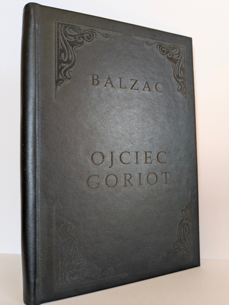 Elegancka, czarna oprawa książki 'Ojciec Goriot' Balzaca z wytłoczonym tytułem i zdobieniami w rogach, prezentowana w zbliżeniu.