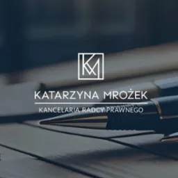 Eleganckie logo kancelarii radcy prawnego Katarzyny Mrożek z inicjałami KM w geometrycznym obramowaniu, umieszczone nad nazwą, widoczne na tle drewnianego biurka z piórami.