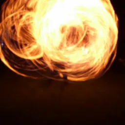 Rozmyte ujęcie kuli ognia na ciemnym tle, prawdopodobnie podczas pokazu fire show.