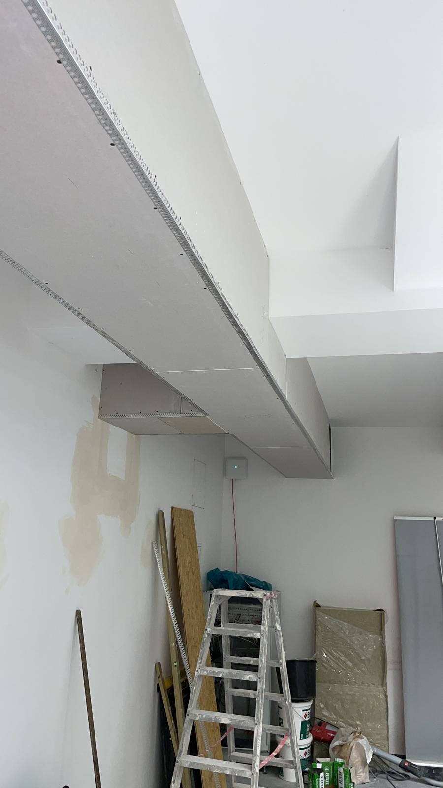 Sufit podwieszany z płyt gipsowo-kartonowych w trakcie montażu w pomieszczeniu w Baniach Mazurskich, widoczne profile i elementy konstrukcyjne.