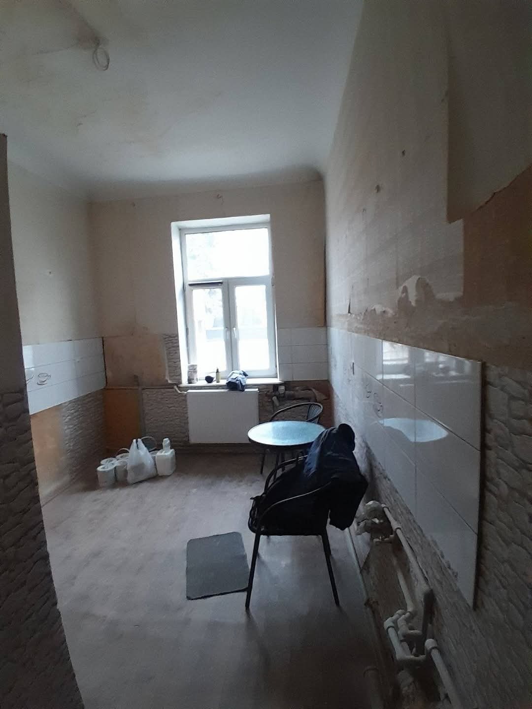 Wnętrze w trakcie prac wykończeniowych w Warszawie. Częściowo położona glazura, widoczne instalacje i materiały budowlane. Przygotowanie do dalszych prac.