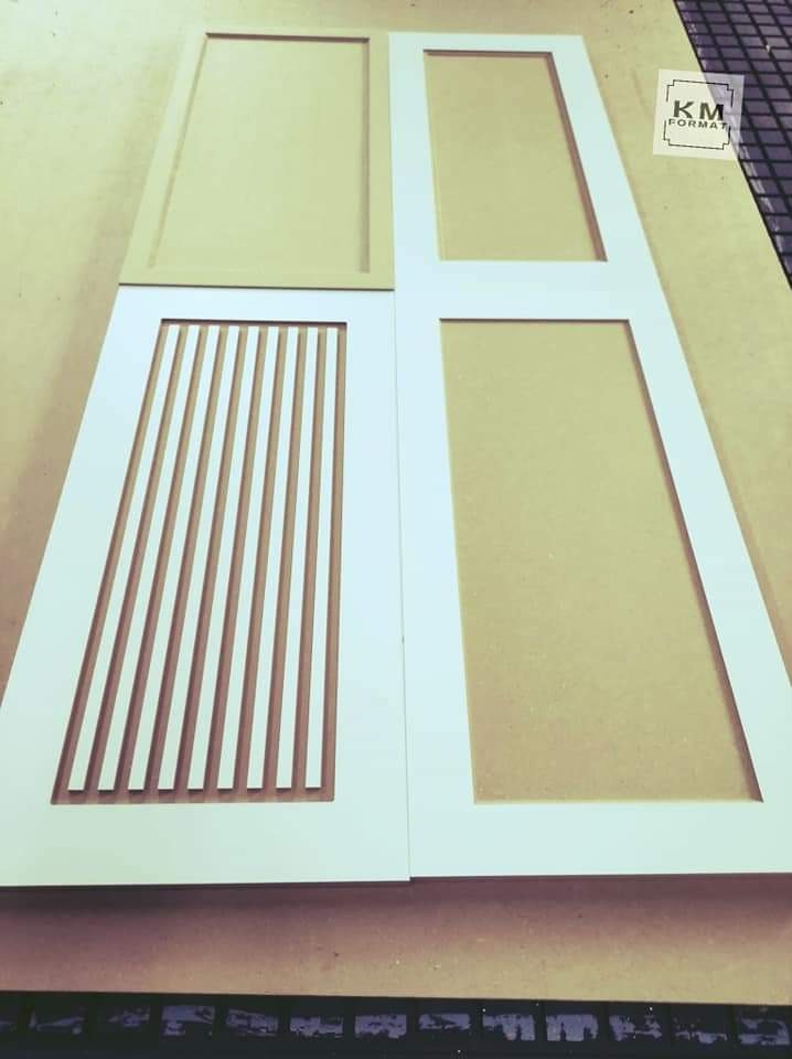 Cztery elementy drewniane: dwa pomalowane na biało z ramami i wypełnieniami (jeden z pionowymi listwami), dwa surowe, przygotowane do dalszej obróbki.