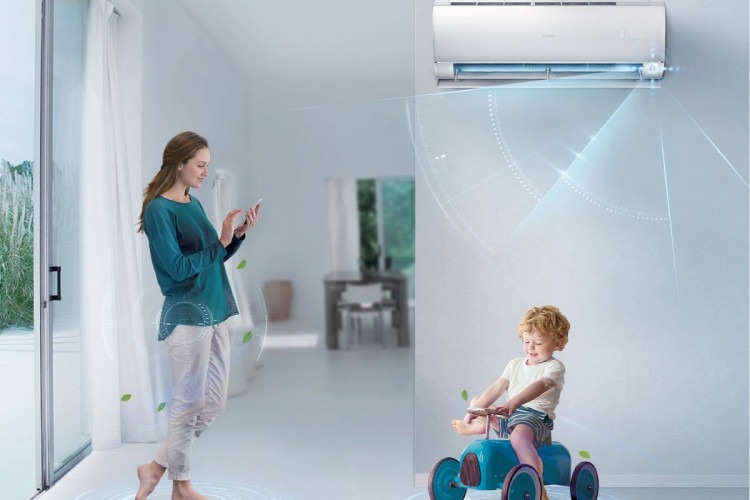 Nowoczesny klimatyzator ścienny w jasnym wnętrzu, z wizualizacją przepływu powietrza, obok kobieta z telefonem i dziecko na zabawkowym samochodzie.