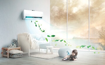 Biały klimatyzator ścienny LG w pokoju dziecięcym, z wizualizacją czystego powietrza w postaci zielonych liści, małe dziecko siedzi na podłodze obok pufy.