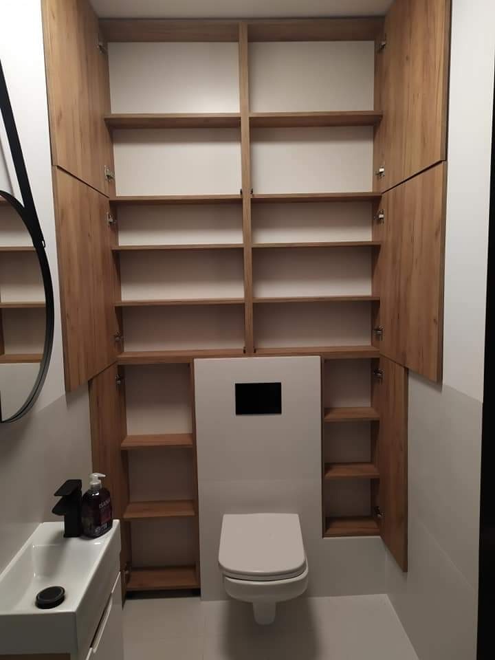 Nowoczesna łazienka z drewnianymi szafkami na wymiar z otwartymi półkami, umywalką nablatową i toaletą podwieszaną.