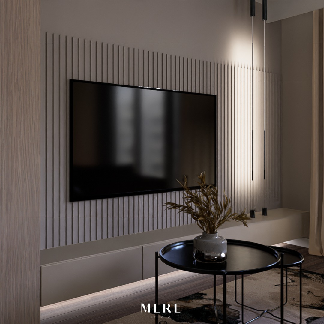 Nowoczesny salon z telewizorem na ścianie z pionowymi panelami, czarne stoliki kawowe z wazonem z suchymi gałązkami, podświetlane szafki RTV, minimalistyczne lampy wiszące.