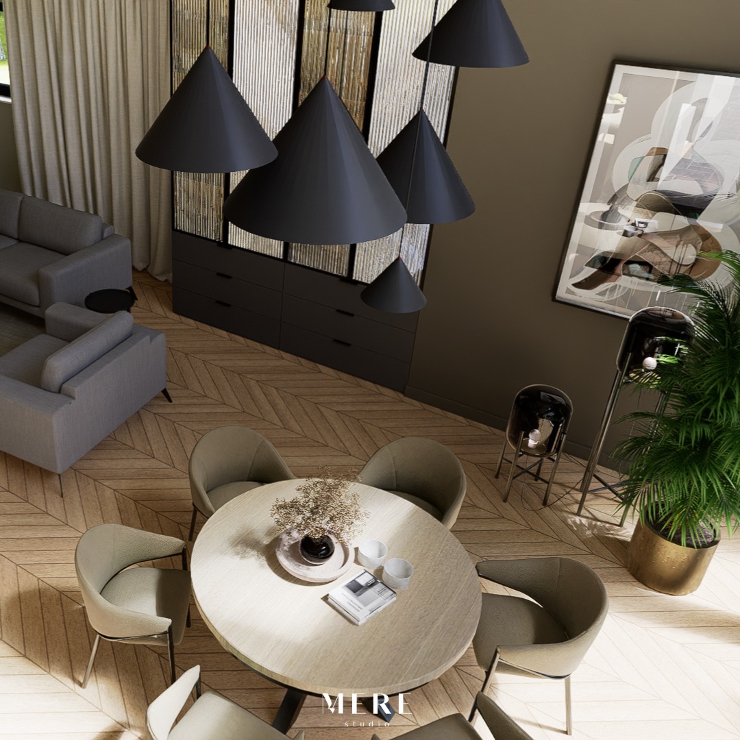 Wysoki kąt widzenia na jadalnię z okrągłym stołem, krzesłami w odcieniach szarości, wiszącymi lampami w kształcie stożków i parkietem ułożonym w jodełkę, uzupełnioną rośliną doniczkową...