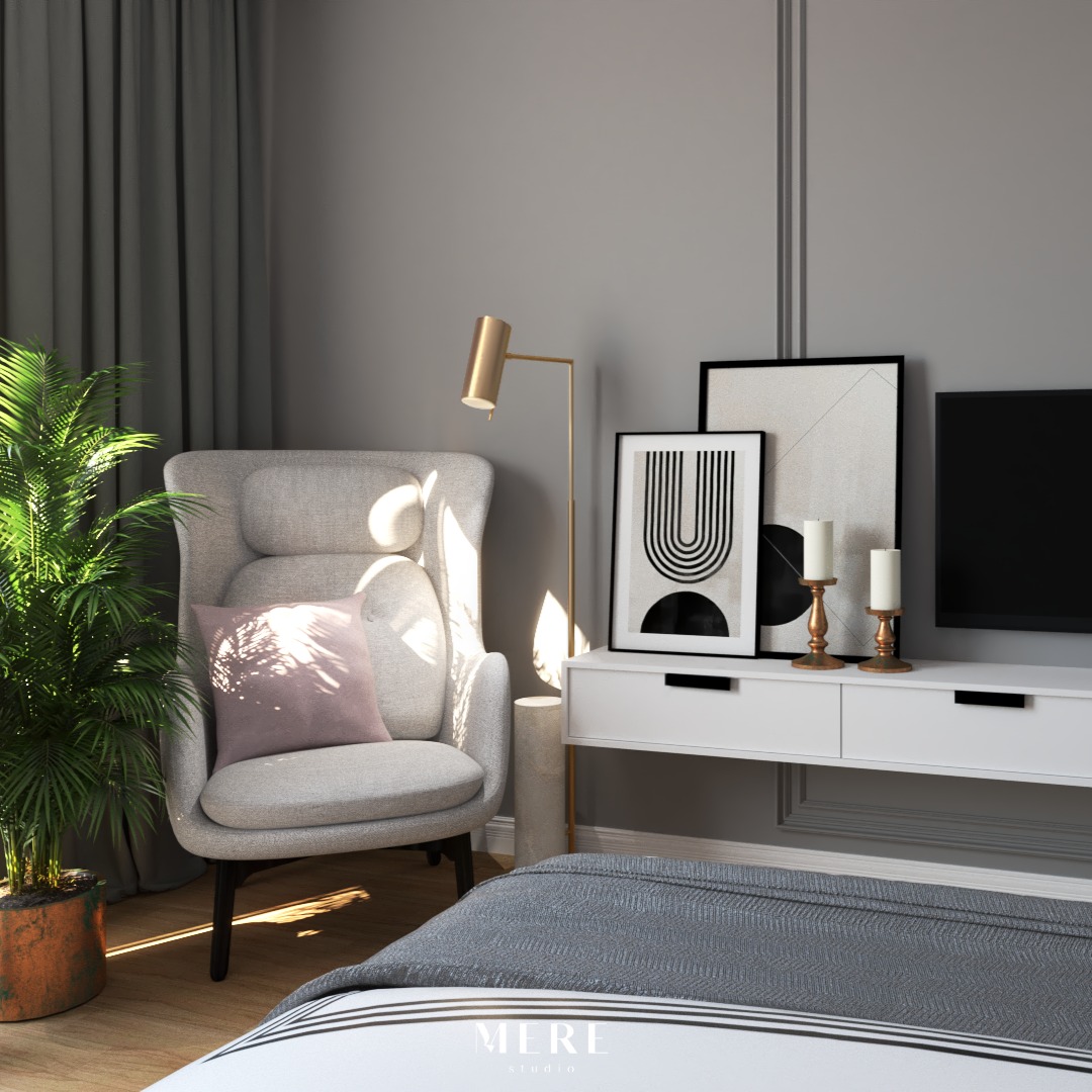Nowoczesny pokój dzienny z szarym fotelem uszakiem, różową poduszką, palmą w doniczce, złotą lampą podłogową i minimalistycznymi obrazami na białej komodzie.