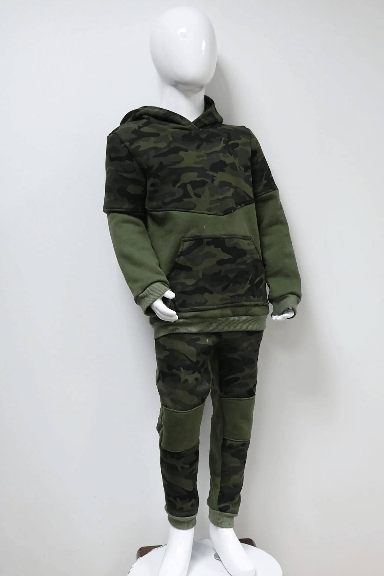 Dziecięcy dres moro z kapturem, prezentowany na białym manekinie na tle białej ściany.