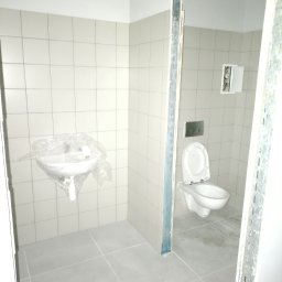 MIŁOSZ TOMKOWICZ - Wykończona łazienka w jasnych płytkach z umywalką pod folią ochronną i toaletą w głębi. Widoczne profile metalowe przy wejściu. Minimalistyczny design.