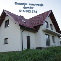 DMX USŁUGI TRANSPORTOWO - BUDOWLANE Jarosław Wolski - Jasna elewacja domu jednorodzinnego z czerwoną dachówką, widok z dołu na tle zieleni. Na elewacji numer telefonu i napis 'Elewacje i renowacje domów'.