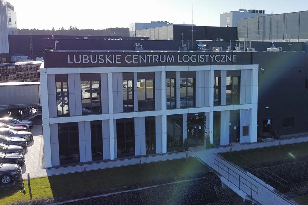 Nowoczesny budynek Lubuskiego Centrum Logistycznego z rzędem zaparkowanych samochodów, widok z góry, słoneczny dzień.