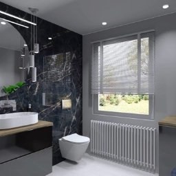 Zbigniew Banasiak - Nowoczesna łazienka z czarnymi płytkami imitującymi marmur, owalną umywalką nablatową, okrągłym lustrem z podświetleniem LED i grzejnikiem żeberkowym pod oknem.