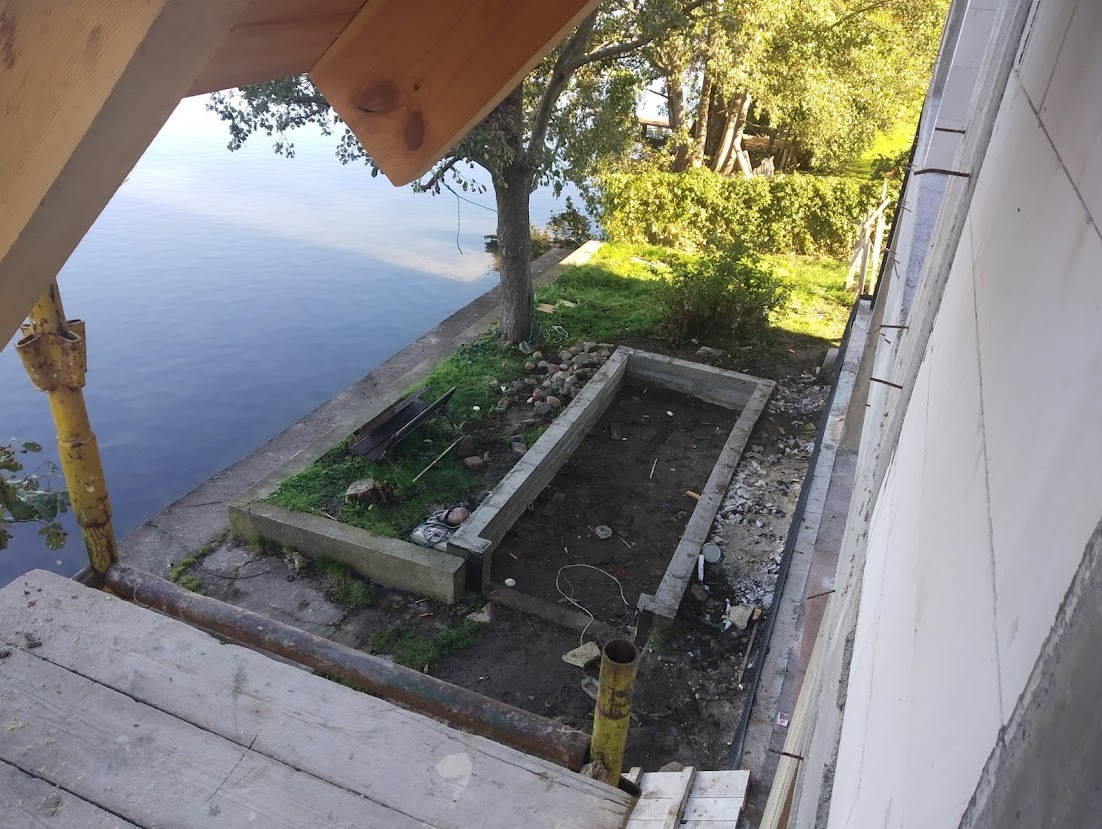 Wykop pod fundamenty domu murowanego na działce przy jeziorze, widok z rusztowania, fragment ściany z betonu komórkowego.