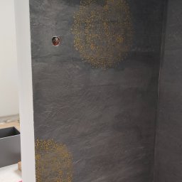 trawertyn pod klatką schodową z złotymi mandalami 