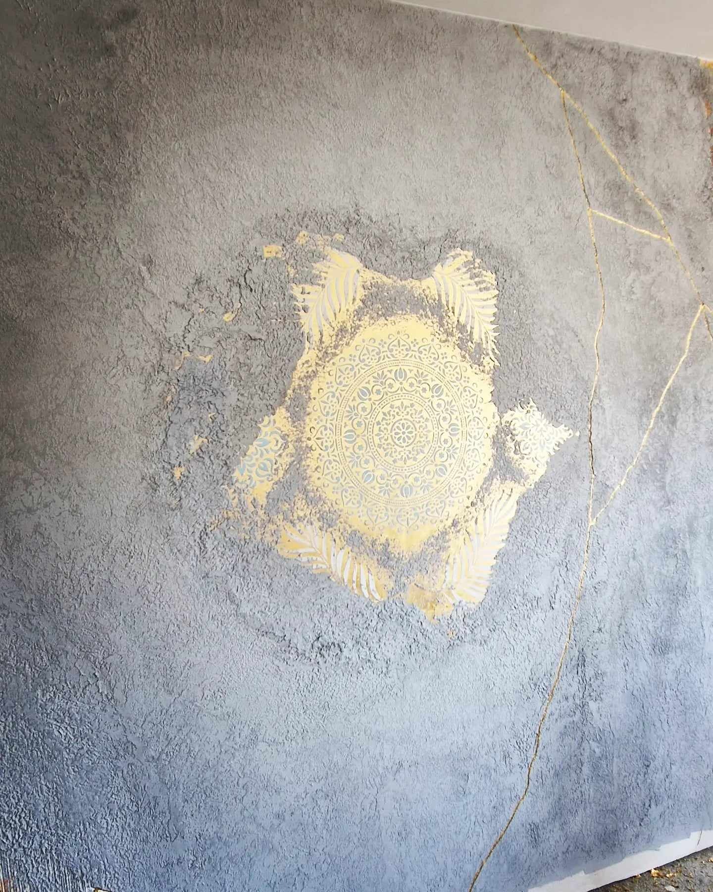 mandala na złocie z złotymi żyłami i szary beton