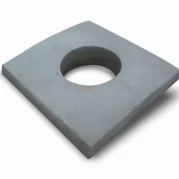Szary, kwadratowy element betonowy z okrągłym otworem pośrodku, leżący na białym tle i rzucający cień.