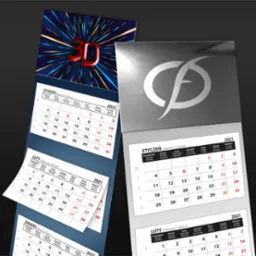 Trzy kalendarze: dwa trójdzielne z widocznymi miesiącami styczeń, luty, marzec 2021, jeden biurkowy z logo firmy w srebrnym kolorze na okładce.