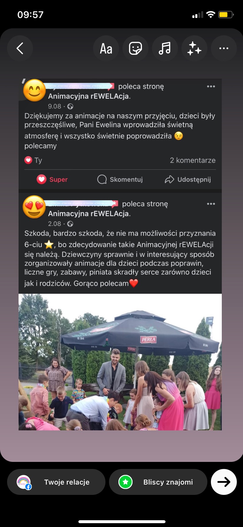 Animator w szarej marynarce nadzoruje grupę dzieci bawiących się na trawie podczas imprezy plenerowej, widoczny parasol reklamowy.