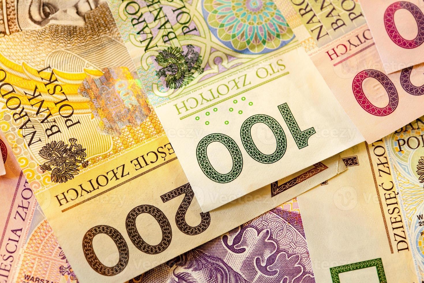 Stos banknotów polskich złotych o nominałach 200, 100 i 50, ułożonych warstwami, z wyraźnymi detalami zabezpieczeń i wzorów.