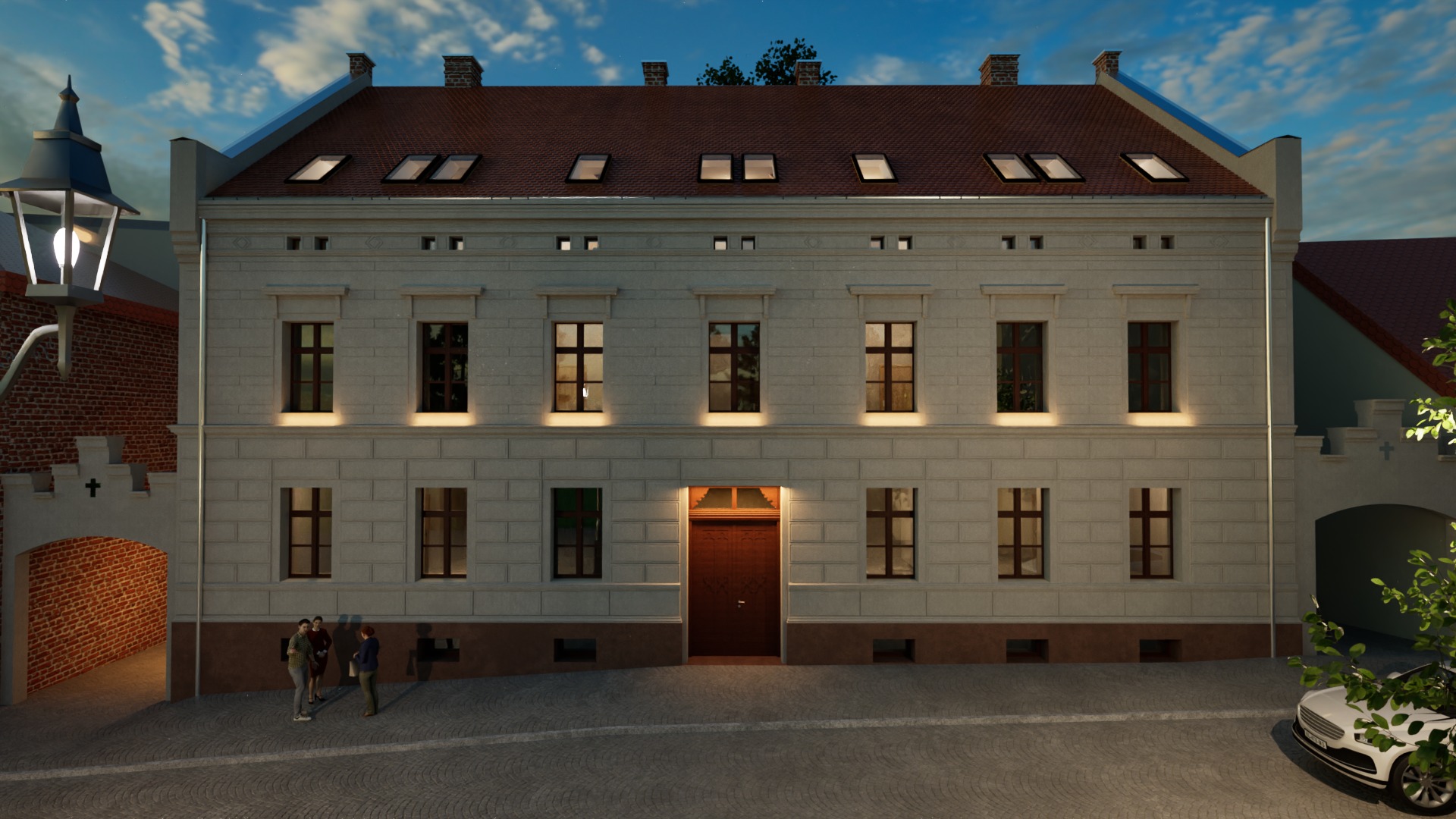 Dwupiętrowy budynek z brązowym dachem i oknami, oświetlony latarniami, z trzema osobami i białym samochodem na brukowanym placu, wczesny wieczór.