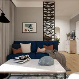 Wizualizacja salonu z niebieską sofą, białym stolikiem kawowym z dekoracyjną figurką kota, oraz ażurową ścianką działową i rośliną doniczkową.