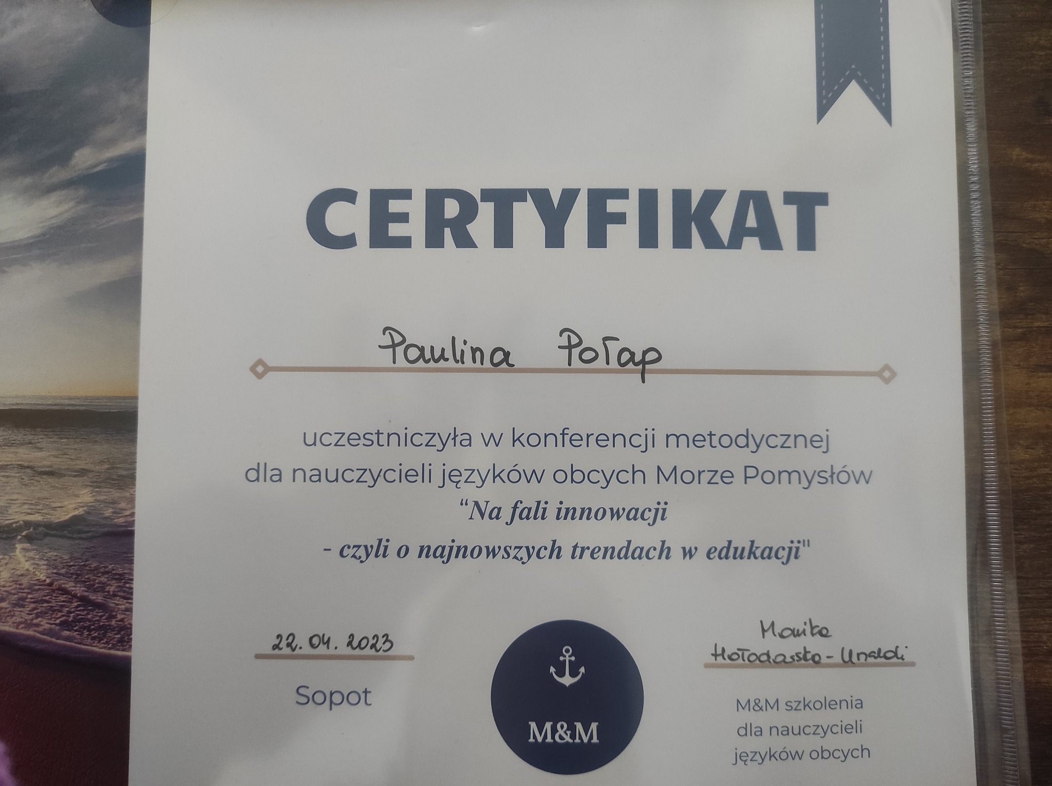 Certyfikat uczestnictwa w konferencji metodycznej dla nauczycieli języków obcych, wydany dla Pauliny Porap, z datą 22.04.2023, Sopot, sygnowany przez M&M szkolenia. W tle widoczny fragment zdjęcia...