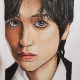 Kamila Sokołowska - Portret młodej osoby z ciemnymi włosami i niebieskimi oczami, wykonany w technice rysunku kredkami, z widocznym cieniowaniem i detalami twarzy, podpisany 'Kamila Sokołowska'.