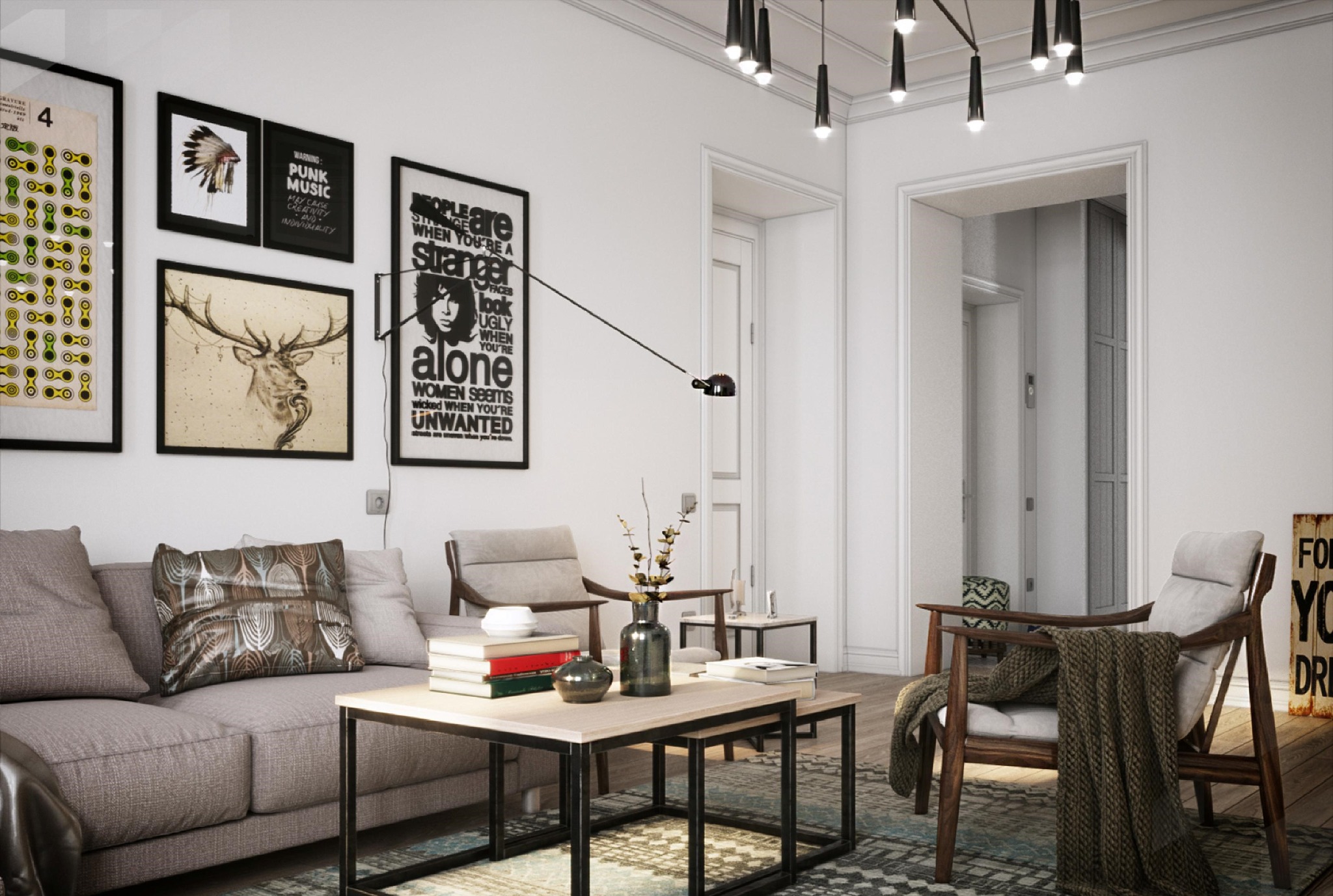 Jasne wnętrze salonu z szarą sofą, drewnianymi fotelami, stolikami kawowymi i dywanem w geometryczne wzory, ściany zdobią grafiki w czarnych ramach, oświetlenie stanowią nowoczesne lampy wiszące.