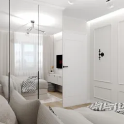 Nowoczesna aranżacja sypialni z lustrzanymi drzwiami szafy, szarą sofą, dekoracyjnymi lampami ściennymi i subtelnym oświetleniem sufitowym, widoczne odbicie ł&oacute;żka z wzorzystą narzutą.