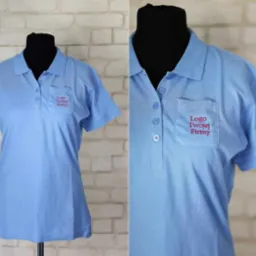 Jasnoniebieska koszulka polo z krótkim rękawem i kieszenią, na której czerwonym haftem umieszczono napis 'Logo Twojej Firmy', prezentowana na czarnym manekinie na tle ściany z białej cegły.