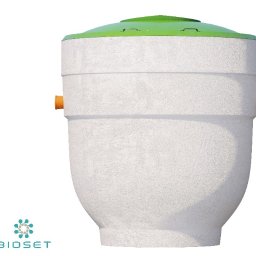 AVITECH MICHAŁ ARAK - Szambo betonowe BioSet z zieloną pokrywą, widok z przodu, z pomarańczowymi przyłączami. Teksturowana powierzchnia zbiornika. Minimalistyczne tło.